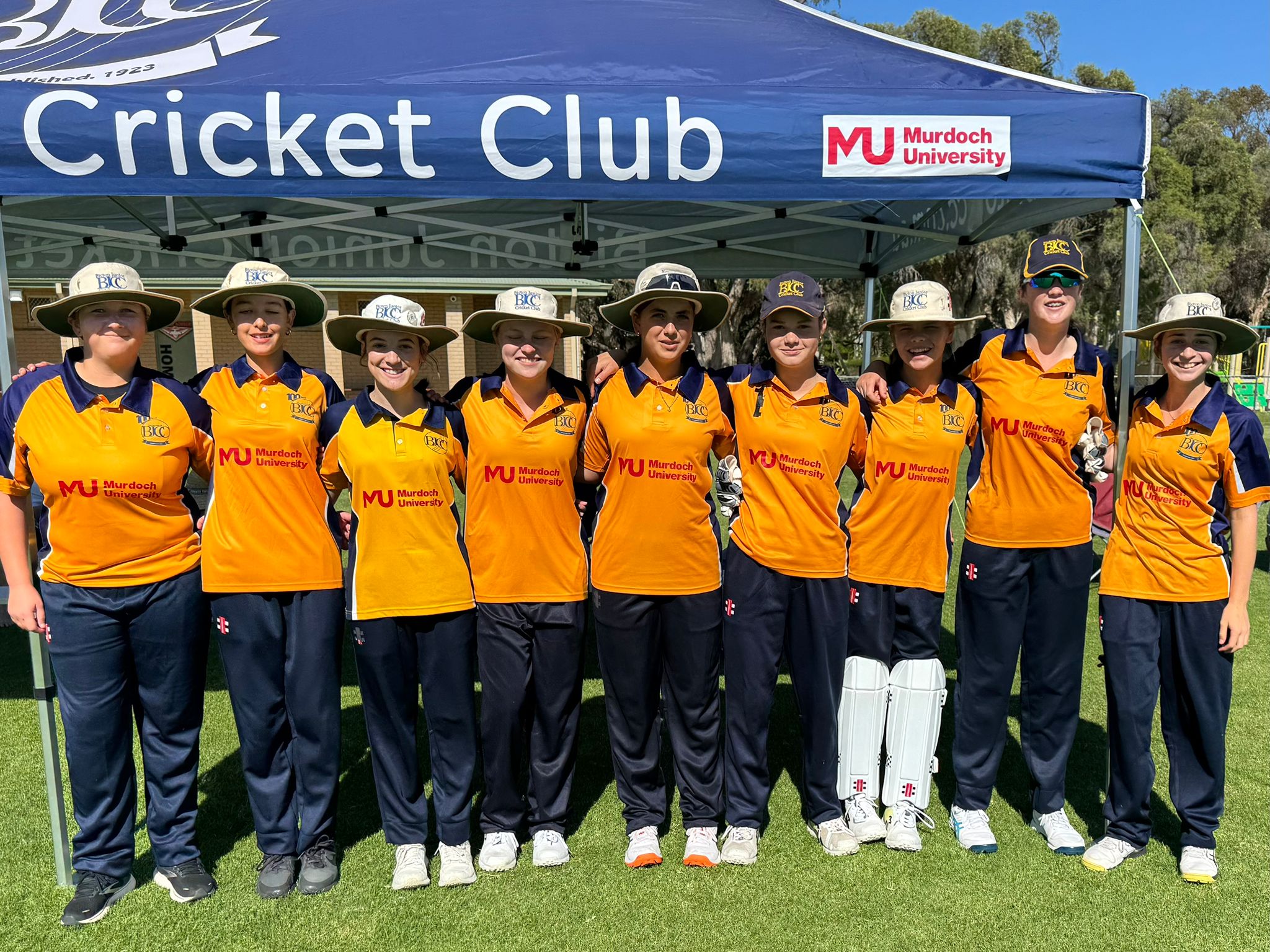 Bicton Junior Cricket Club players wearing Murdoch University sponsored shirts